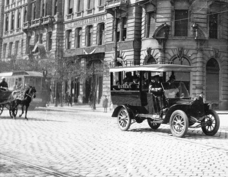 Cars and horse-drawn carriages navigating Budapest